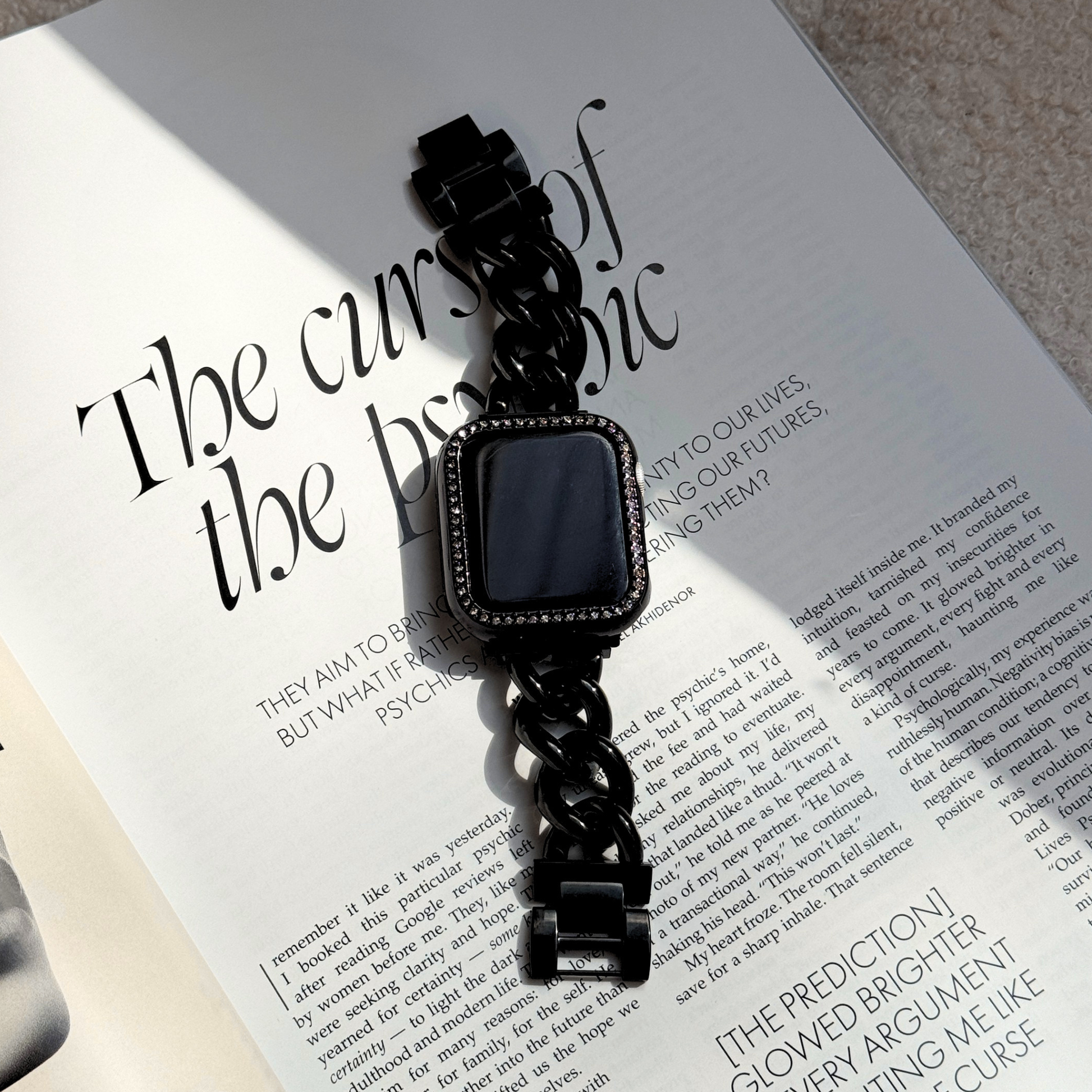 black apple watch chain band with a black rhinestone apple watch case on a stylish journal
