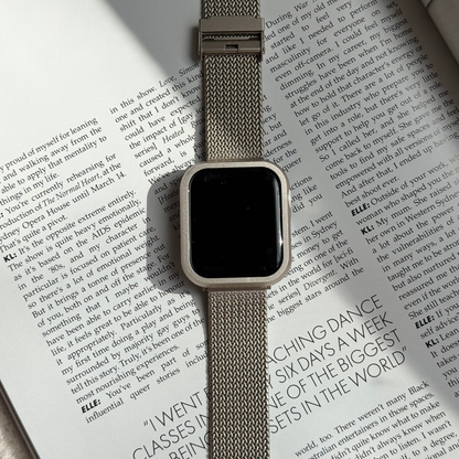 Starlight stainless steel Apple Watch case cover shown on an open book with a mesh band. Refined protective bumper, available for Apple Watch 38mm to 49mm, Series 1-11, SE and Ultra
