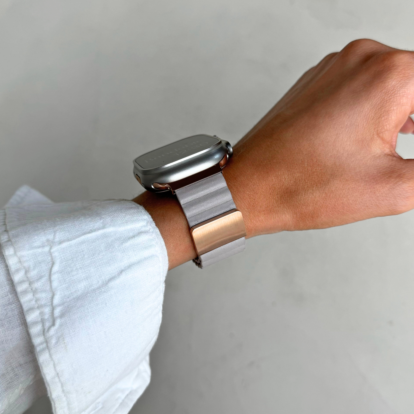 Light grey ribbed vegan leather Apple Watch band worn on a wrist against a plain backdrop. Magnetic iWatch strap that goes on one handed, compatible with Apple Watch 38mm to 49mm, Series 1-11, SE and Ultra