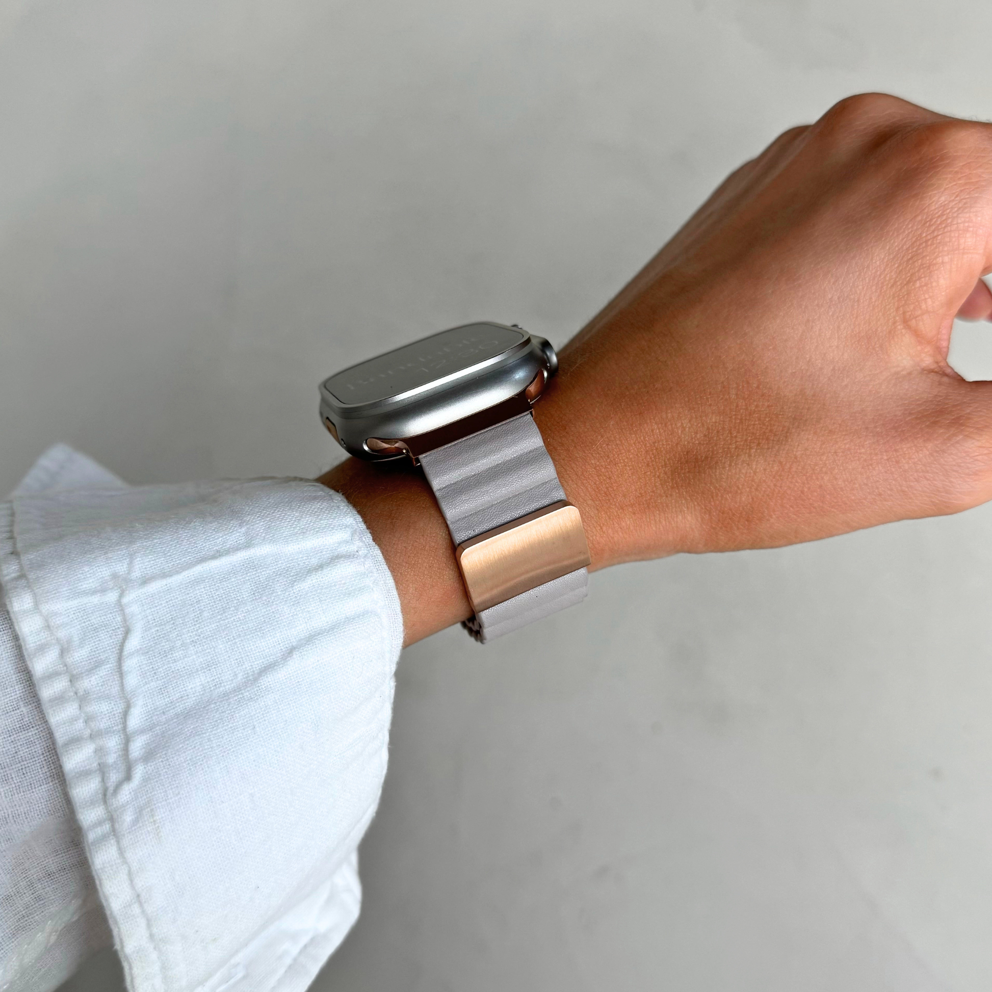 Light grey ribbed vegan leather Apple Watch band worn on a wrist against a plain backdrop. Magnetic iWatch strap that goes on one handed, compatible with Apple Watch 38mm to 49mm, Series 1-11, SE and Ultra