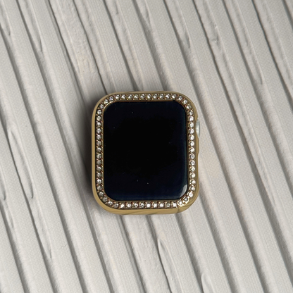 Gold rhinestone apple watch case on a textured surface