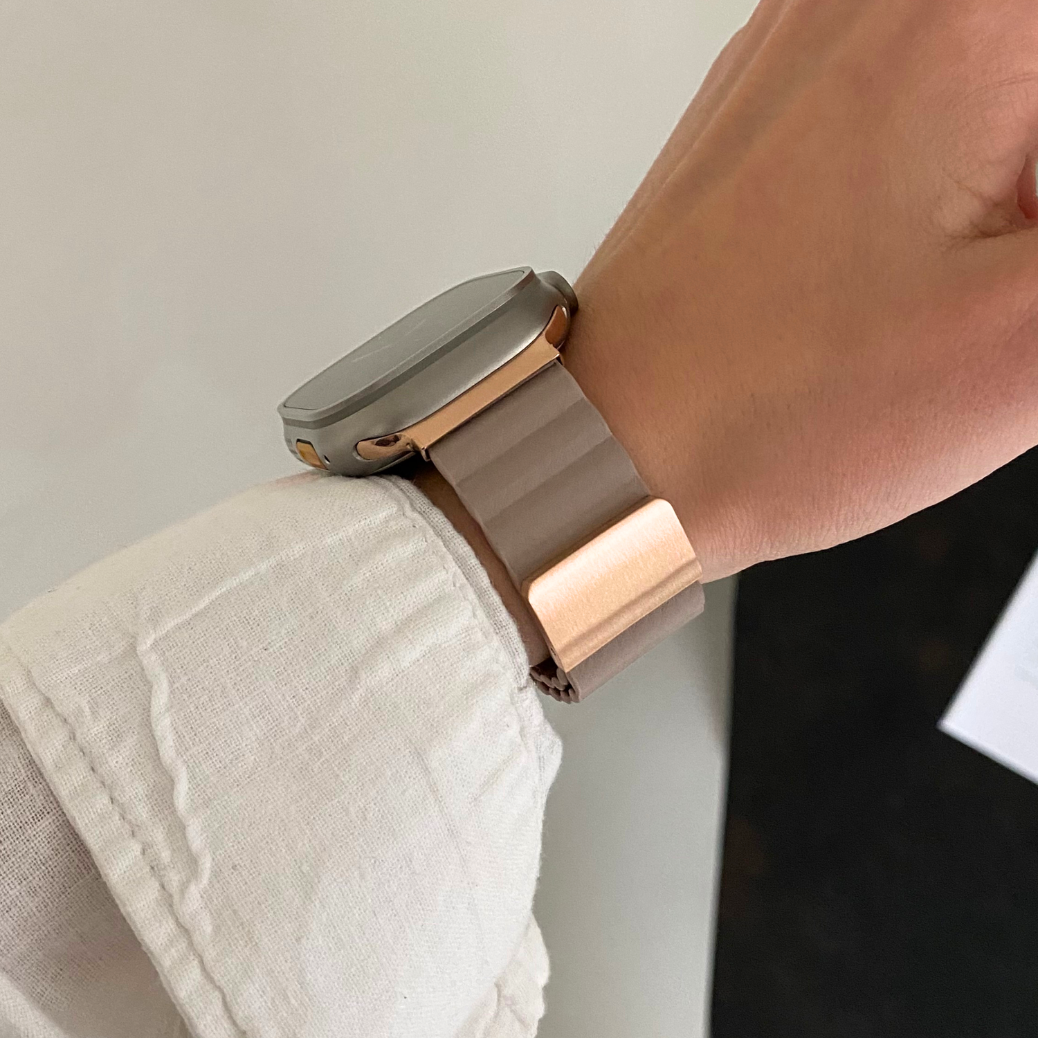 Starlight ribbed vegan leather Apple Watch band worn on a wrist with a pale linen cuff. Magnetic iWatch strap that closes with no buckle or holes, compatible with Apple Watch 38mm, 40mm, 41mm, 42mm, 44mm, 45mm, 46mm and 49mm, Series 1-11, SE and Ultra