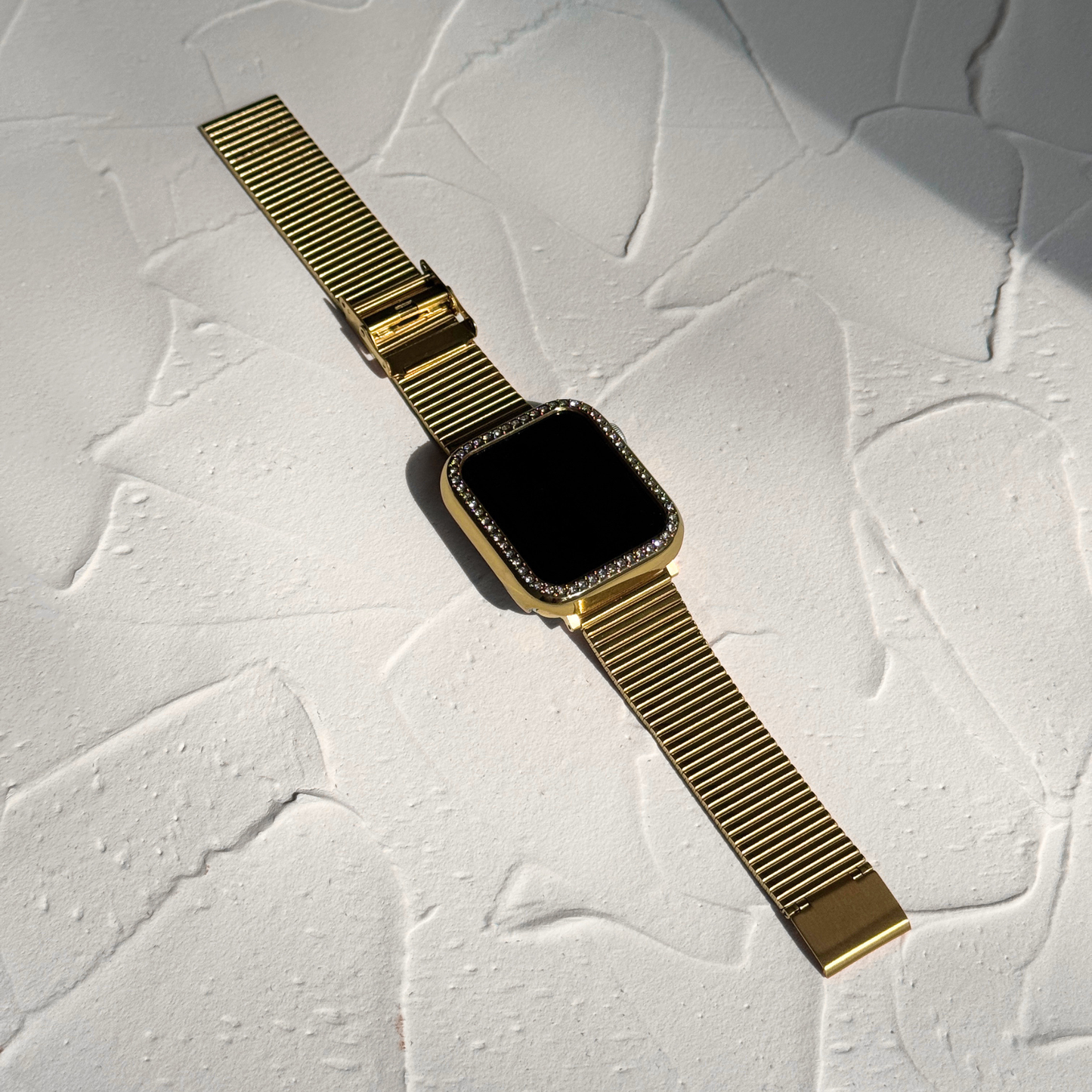 Apple smartwatch with a textured background with a Gold rhinestone apple watch case and a golden band