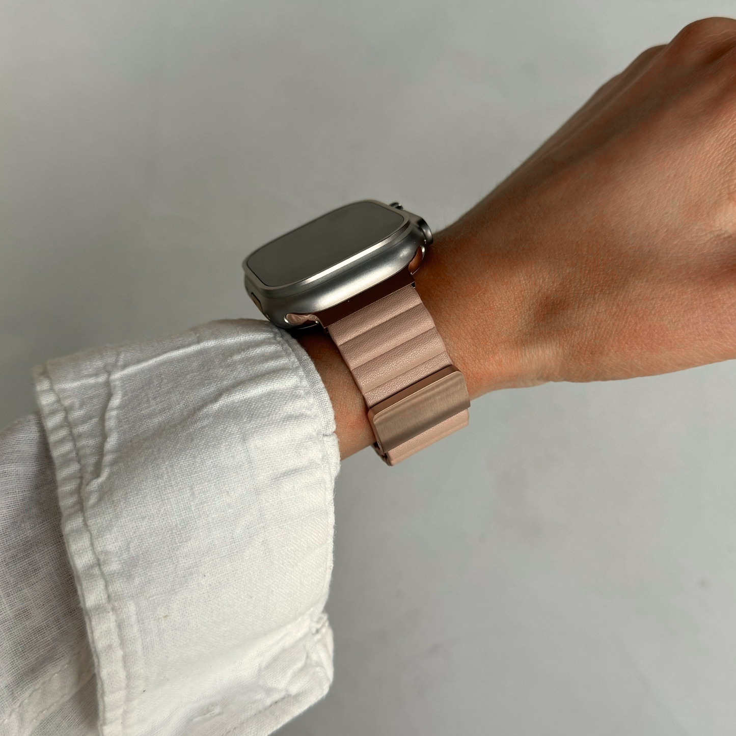 Nude ribbed vegan leather Apple Watch band worn on a wrist with a rolled linen sleeve. Soft magnetic iWatch strap in a neutral tone, compatible with Apple Watch 38mm to 49mm, Series 1-11, SE and Ultra
