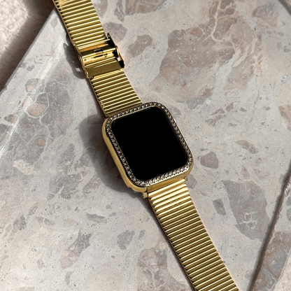 Apple watch with on a marble surface with a gold rhinestone apple watch case