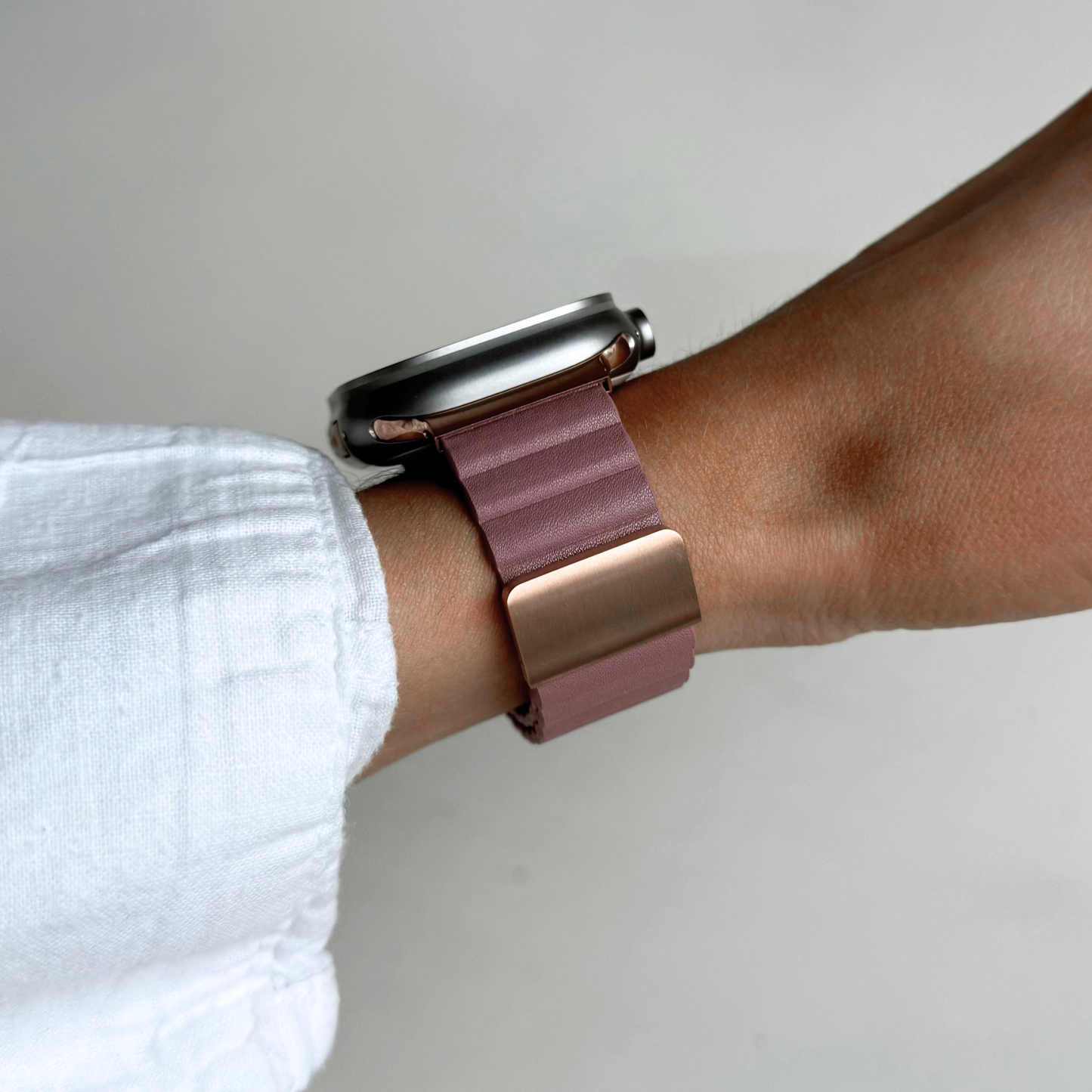 Blush ribbed vegan leather Apple Watch band worn on a wrist with a soft linen cuff. Magnetic iWatch strap that sits exactly where you want it, compatible with Apple Watch 38mm to 49mm, Series 1-11, SE and Ultra