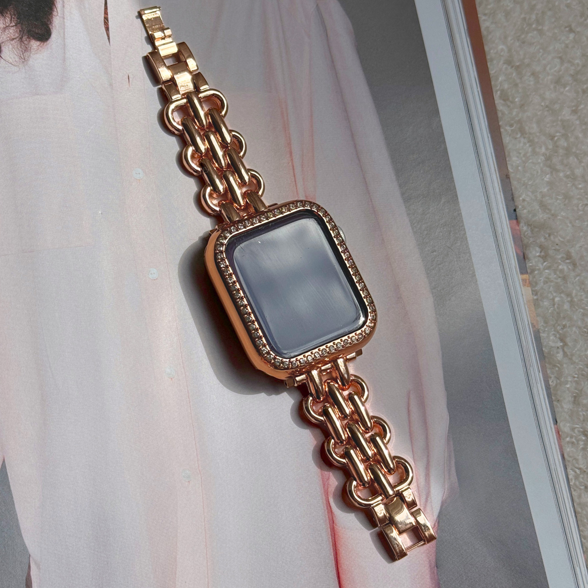 Rose gold chain apple watch bracelet with a rose Gold rhinestone apple watch case on a journal