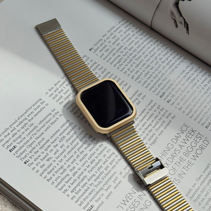 Gold stainless steel Apple Watch case cover shown on an open magazine with a mesh band. Durable protective bumper, available for Apple Watch 38mm to 49mm, Series 1-11, SE and Ultra