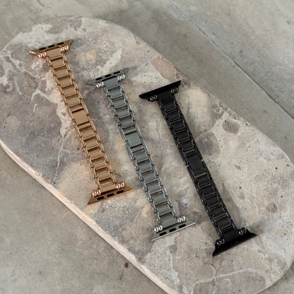 Rose gold, silver and black slim link Apple Watch bands laid out on a stone tray. Feminine metal iWatch straps and bracelets, compatible with Apple Watch 38mm to 49mm, Series 1-11, SE and Ultra