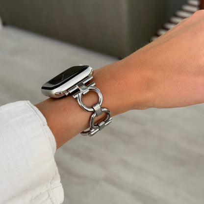 Silver circle link Apple Watch band worn on a wrist with a white linen sleeve. Lightweight metal iWatch strap for everyday wear, compatible with Apple Watch 38mm to 49mm, Series 1-11, SE and Ultra