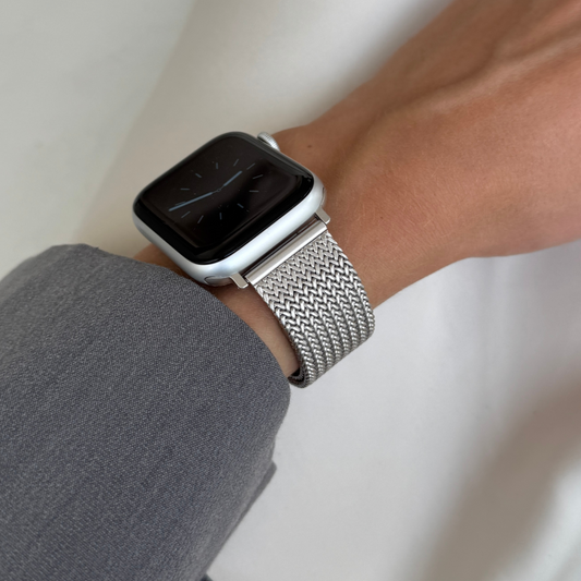 Starlight mesh loop Apple Watch band worn on a wrist with a grey sleeve. Waterproof stainless steel iWatch strap, compatible with Apple Watch 38mm, 40mm, 41mm, 42mm, 44mm, 45mm, 46mm and 49mm, Series 1-11, SE and Ultra