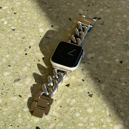 Silver chain link Apple Watch band lying on a terrazzo surface. Bold waterproof stainless steel iWatch bracelet with oversized links, compatible with Apple Watch 38mm, 40mm, 41mm, 42mm, 44mm, 45mm, 46mm and 49mm, Series 1-11, SE and Ultra