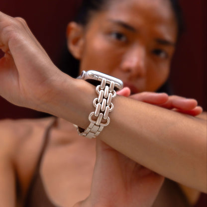Starlight chain link Apple Watch band worn on a wrist against a deep red backdrop. Fashionable metal iWatch bracelet with a high polish shine, compatible with Apple Watch 38mm, 40mm, 41mm, 42mm, 44mm, 45mm, 46mm and 49mm, Series 1-11, SE and Ultra