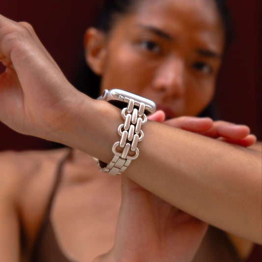 Starlight chain link Apple Watch band worn on a wrist against a deep red backdrop. Fashionable metal iWatch bracelet with a high polish shine, compatible with Apple Watch 38mm, 40mm, 41mm, 42mm, 44mm, 45mm, 46mm and 49mm, Series 1-11, SE and Ultra