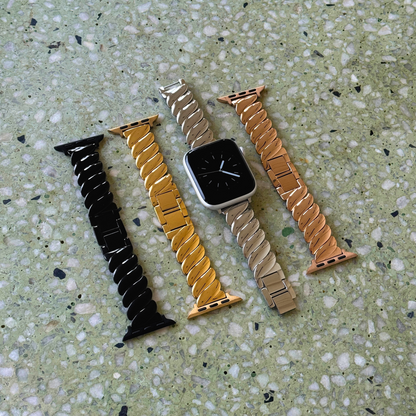 Black, gold, silver and rose gold twisted link Apple Watch bands laid out on terrazzo. Waterproof stainless steel iWatch straps, compatible with Apple Watch 38mm to 49mm, Series 1-11, SE and Ultra