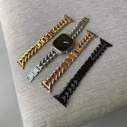 Gold, silver, rose gold and black chunky chain Apple Watch bands laid out on grey fabric. Luxury metal iWatch straps and armbands, compatible with Apple Watch 38mm to 49mm, Series 1-11, SE and Ultra