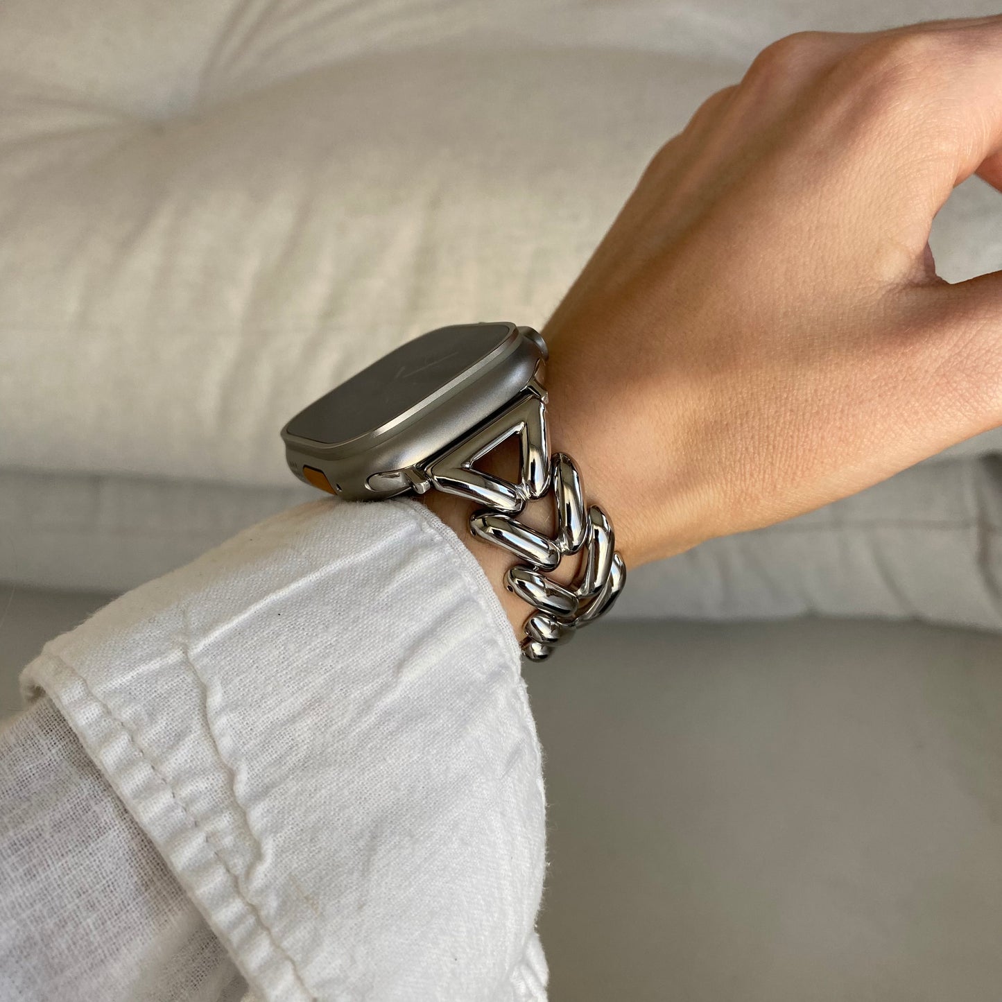 Silver chunky chain Apple Watch band worn with a white linen cuff on a cushion. Luxury metal iWatch strap for women, compatible with Apple Watch 38mm to 49mm, Series 1-11, SE and Ultra