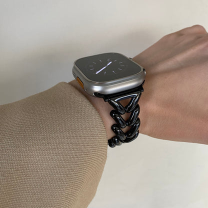 Black chunky chain Apple Watch band worn on a wrist with a beige knit sleeve. Metal iWatch bracelet for everyday wear, compatible with Apple Watch 38mm to 49mm, Series 1-11, SE and Ultra