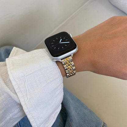 Silver gold woven link Apple Watch band worn with a white linen cuff over denim, stainless steel strap for Apple Watch 38mm to 49mm