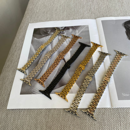 Silver, gold, rose gold, black, starlight, silver gold and silver rose gold woven link Apple Watch bands laid out on a magazine, stainless steel straps for Apple Watch 38mm to 49mm