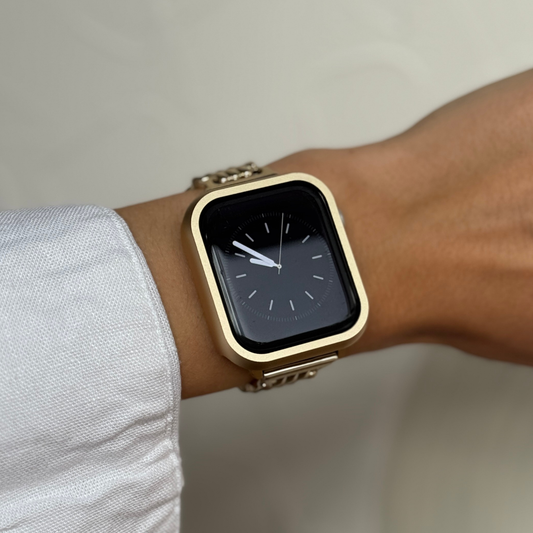 Gold stainless steel Apple Watch case cover worn on a wrist with a matching gold band. Premium protective bumper, available for Apple Watch 38mm, 40mm, 41mm, 42mm, 44mm, 45mm, 46mm and 49mm, Series 1-11, SE and Ultra