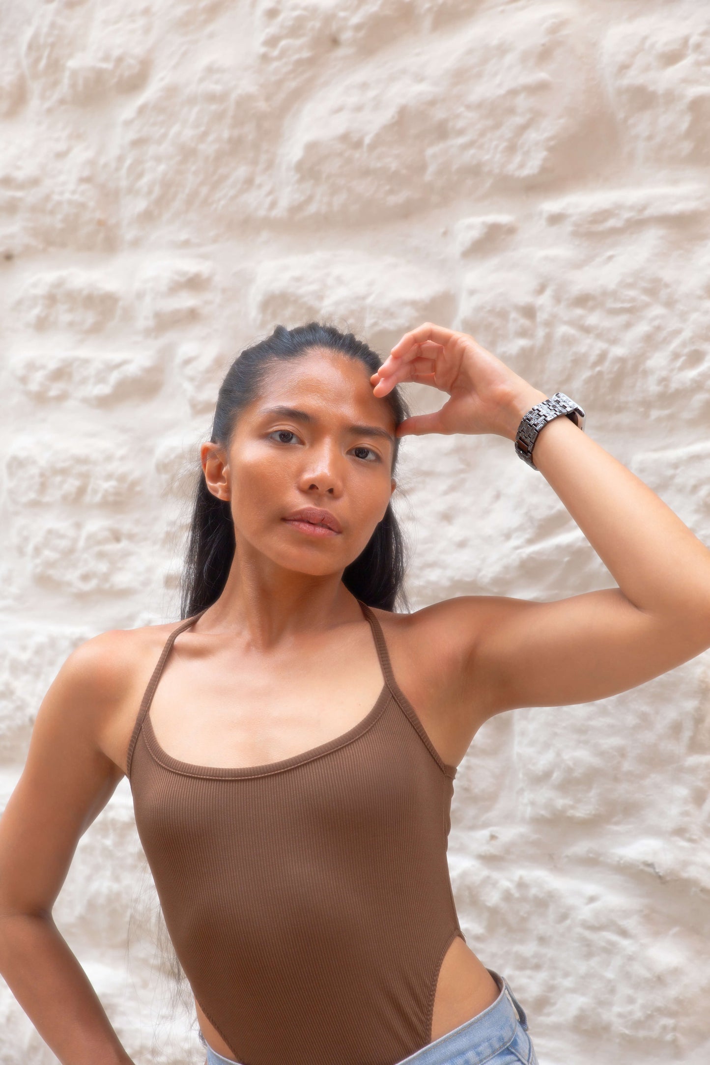 Black baroque pattern Apple Watch band worn by a woman against a white stone wall. Vintage inspired metal iWatch armband, compatible with Apple Watch 38mm to 49mm, Series 1-11, SE and Ultra
