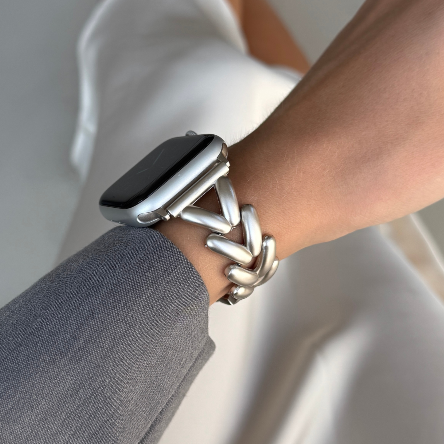 Starlight chunky chain Apple Watch band worn with a grey blazer sleeve. Luxurious metal iWatch bracelet with a beautiful shine, compatible with Apple Watch 38mm, 40mm, 41mm, 42mm, 44mm, 45mm, 46mm and 49mm, Series 1-11, SE and Ultra