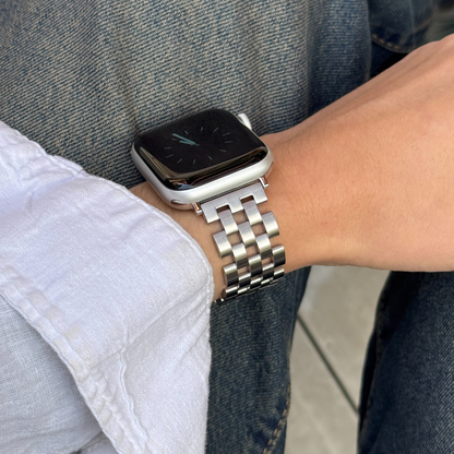 Silver multi link Apple Watch band worn on a wrist over denim. Premium stainless steel iWatch strap with clean geometry, compatible with Apple Watch 38mm to 49mm, Series 1-11, SE and Ultra
